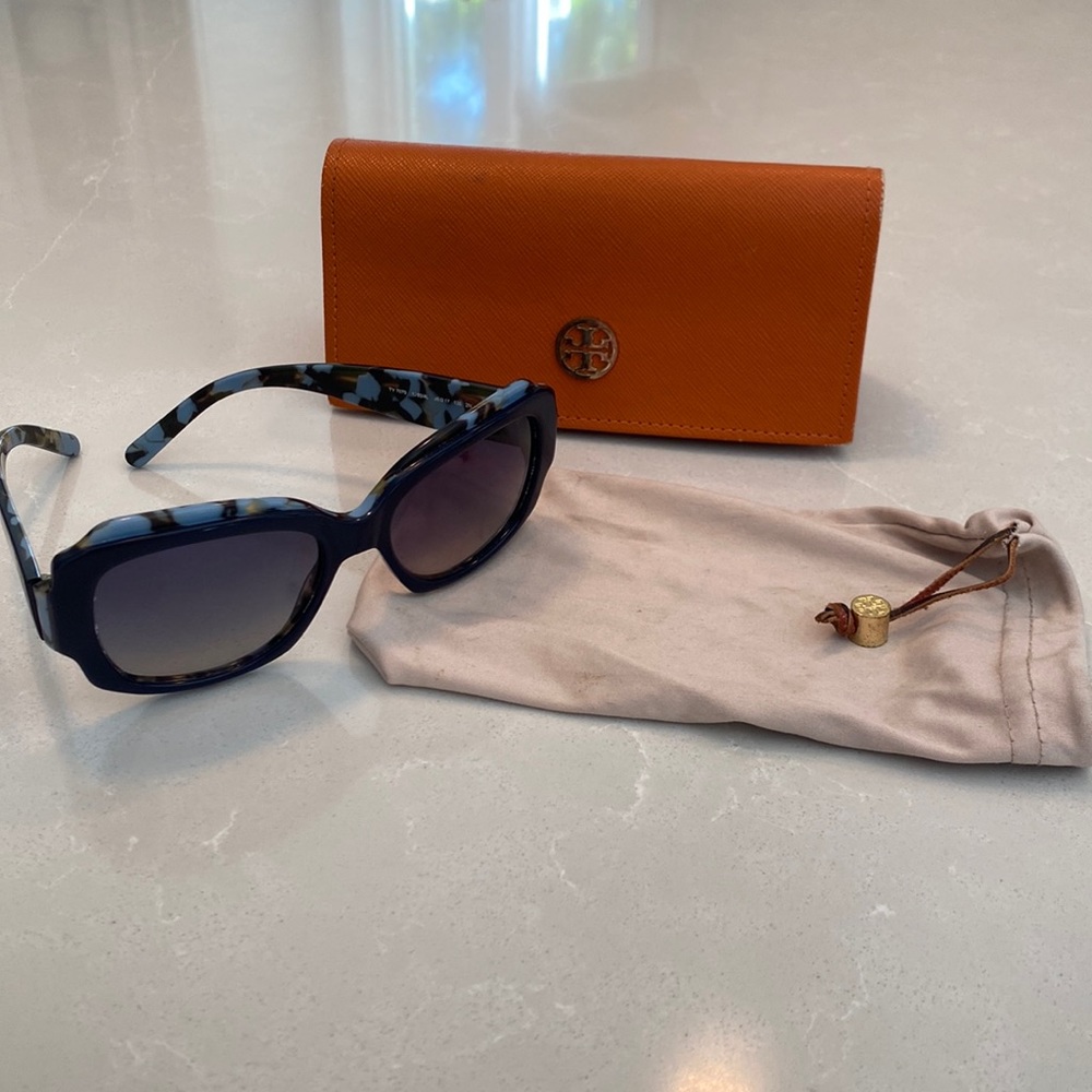 Tory Burch sunglasses, orange case and beige soft drawstring bag.
